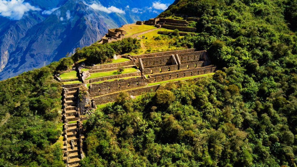 Aerial view of Choquequirao ruins, showcasing the ancient Inca terraces and structures surrounded by lush green mountains, a key stop on the Choquequirao to Machu Picchu trek.