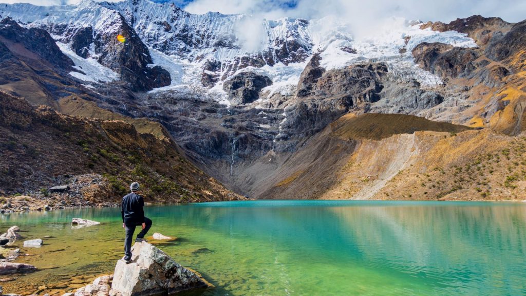 Hiker viewing the turquoise Humantay Lake and Salkantay Glacier, a visual element for the Humantay Lake Guide altitude tips.