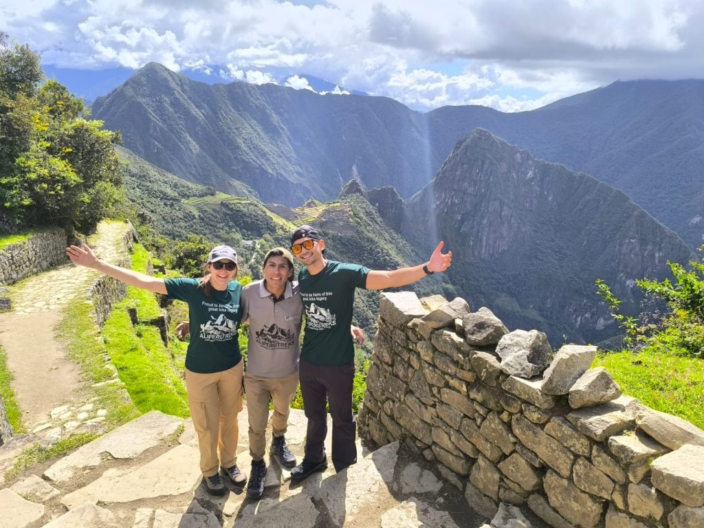 Happy tourists posing with their Machu Picchu private guide overlooking the ruins - Ali Peru Treks