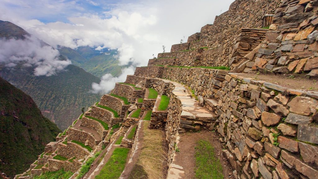 Ancient Inca terraces at Choquequirao, Peru, showcasing the breathtaking stone architecture and lush green landscapes high in the Andes – Ali Peru Treks