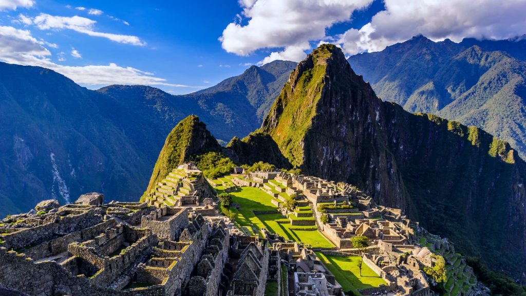 Panoramic view of Machu Picchu, the breathtaking Inca citadel nestled in the Andes Mountains of Peru, bathed in golden sunlight – Ali Peru Treks