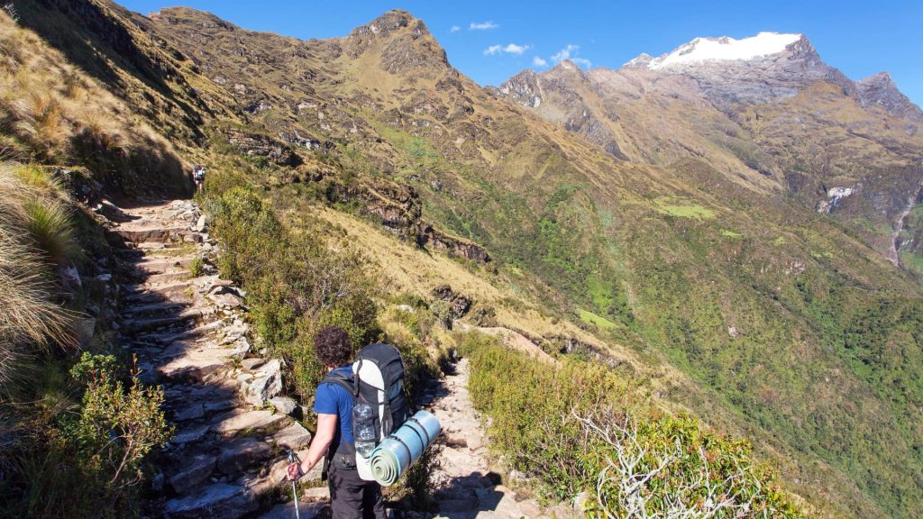 Hiker ascending the trail near Sayacmarca inca trail archaeological site, a strategic mountain lookout - Ali Peru Treks