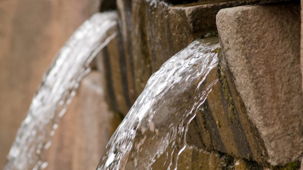 Incan fountains in Tambomachay, an archaeological site near Cusco, with water flowing through stone channels. - Ali Peru Treks