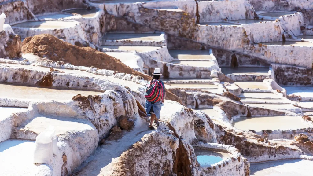 Panoramic view of the stepped salt ponds of Maras glistening under the sun, nestled in the Sacred Valley of Peru – Ali Peru Treks