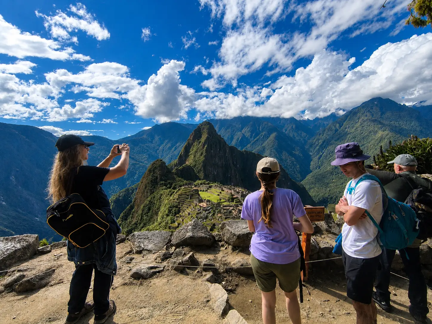 A group of tourists enjoying a breathtaking panoramic view of the Inca citadel of Machu Picchu