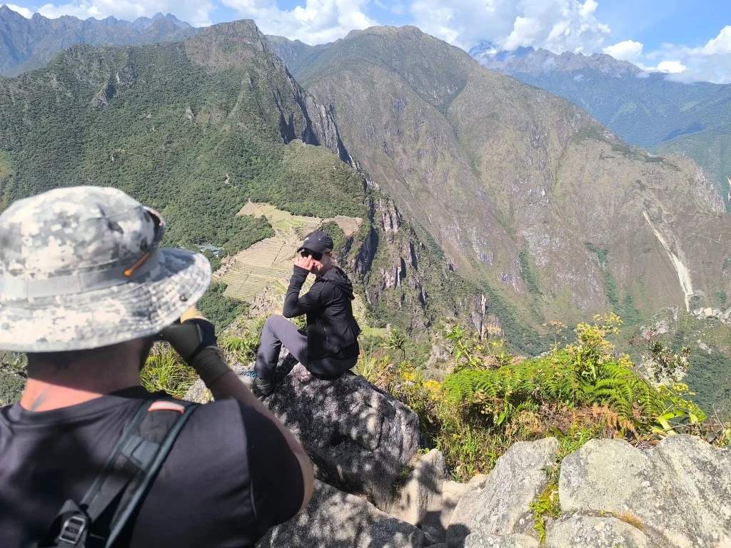 A panoramic view shows the Machu Picchu archaeological site in Peru, with its iconic agricultural terraces and Huayna Picchu Mountain in the background