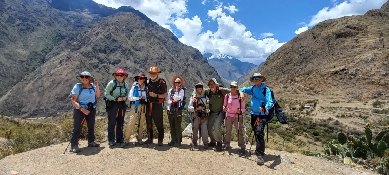 Excursionistas posando con bastones de senderismo en el paisaje montañoso del Valle Sagrado de los Incas, en Perú