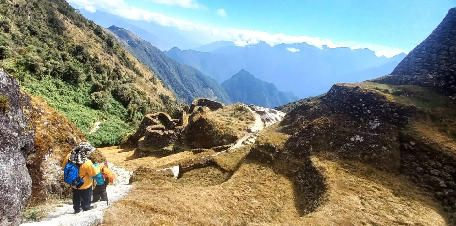Hikers descending stone steps after exploring the Phuyupatamarca ruins