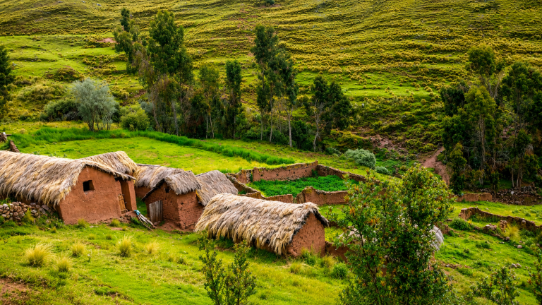 Casas tradicionales andinas de adobe con techos de paja en la zona de Huchuy Qosqo.