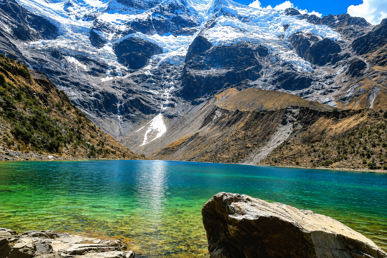 Its turquoise waters and the fact that it is surrounded by majestic glaciers, specifically Mount Salkantay and Mount Humantay