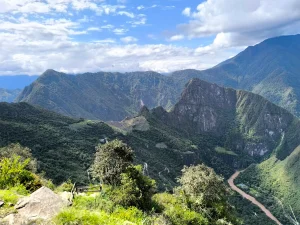 Panoramic view of the Historic Sanctuary of Machu Picchu, featuring Huayna Picchu Mountain on the right and the Urubamba River winding below