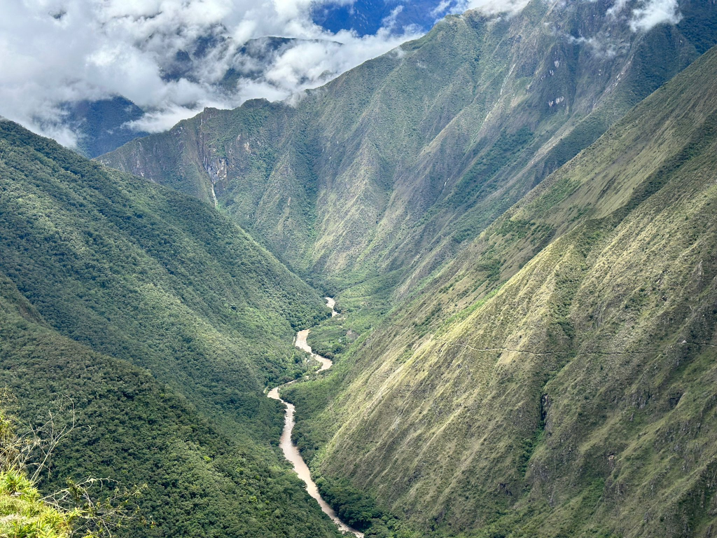 Panoramic view of the Urubamba River winding through the rugged mountains of the Sacred Valley of the Incas in Peru