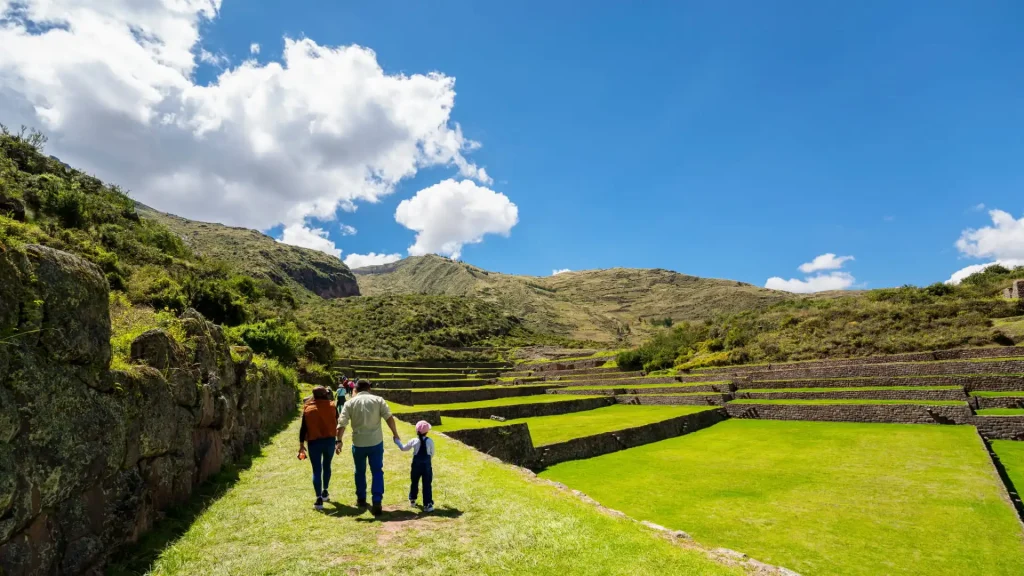 Tourists walking through green terraces in the Andes