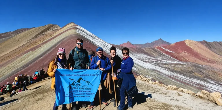 A group of hikers posing at the famous Mountain of Seven Colors (Vinicunca), located about 5,200 meters above sea level in the Cusco region